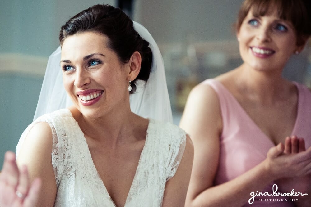 A documentary style photograph of a bride smiling during the wedding speeches