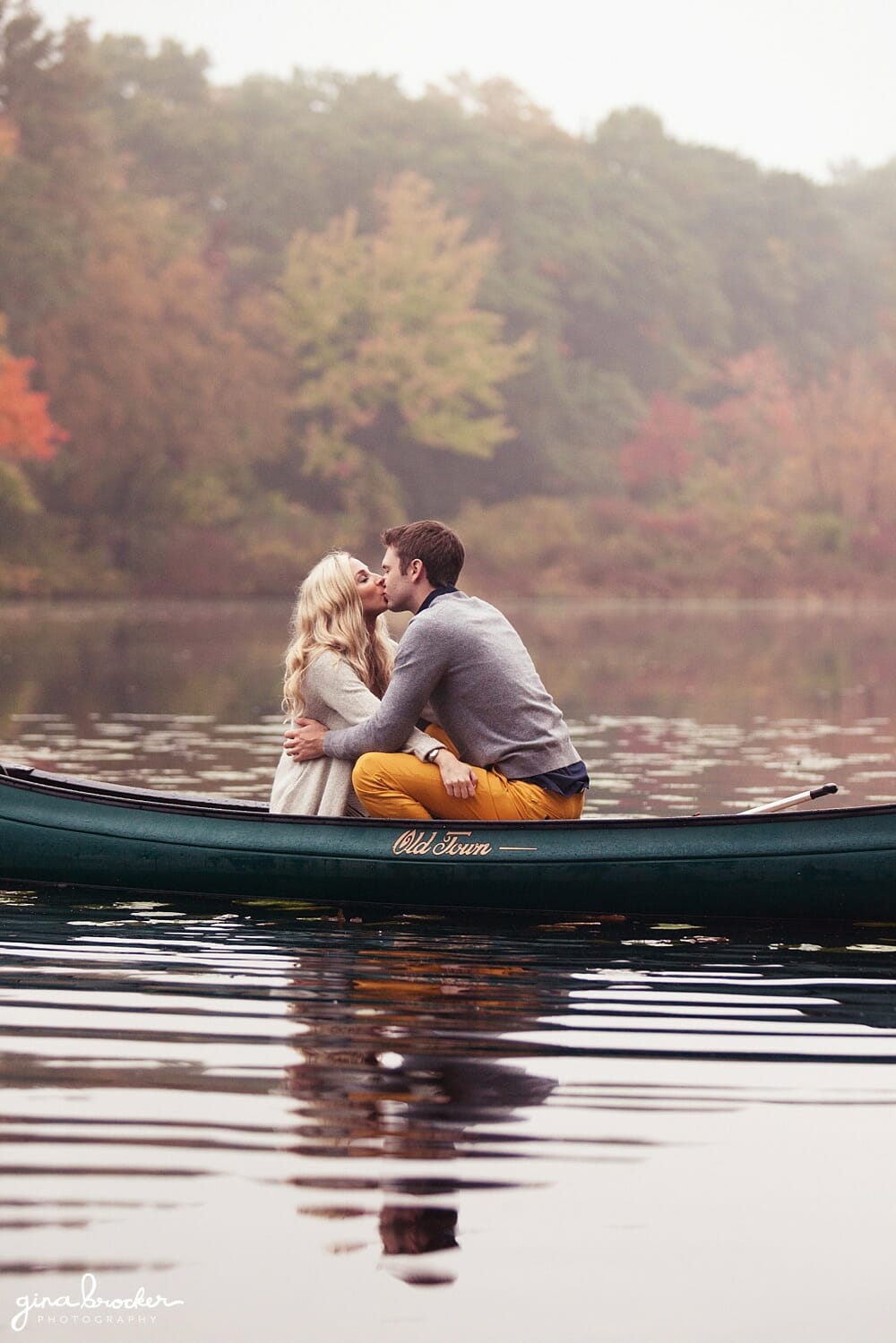 A couple kiss during their canoe trip on charles river during their autumn couple session in boston