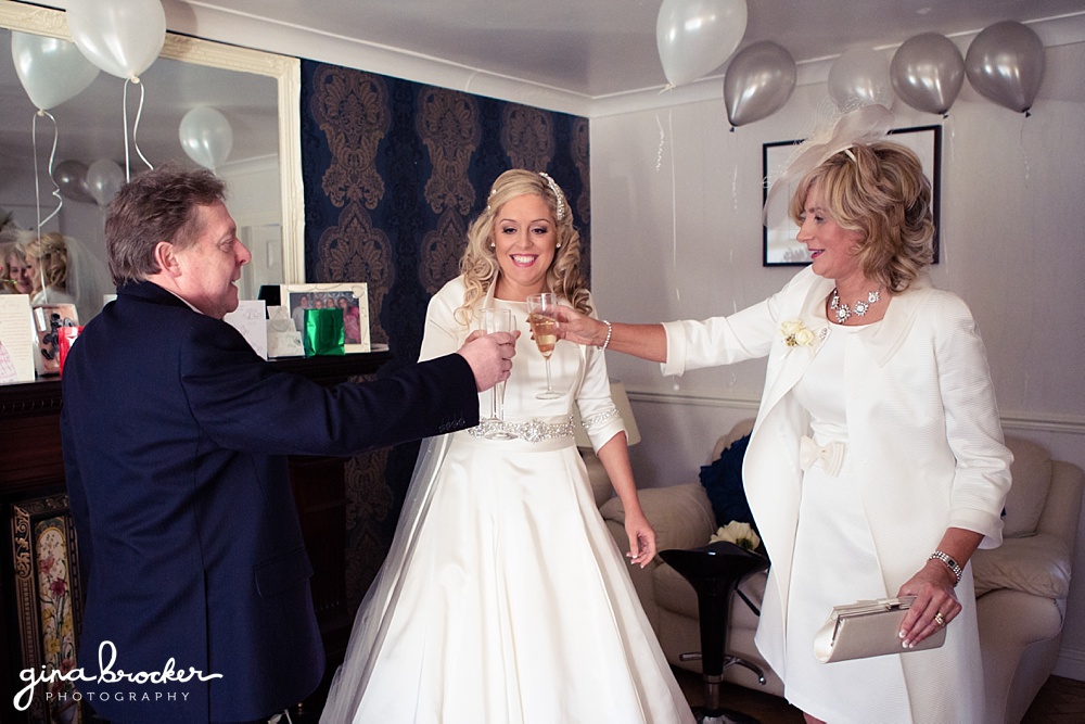 Bride has a champagne toast with her mother and father