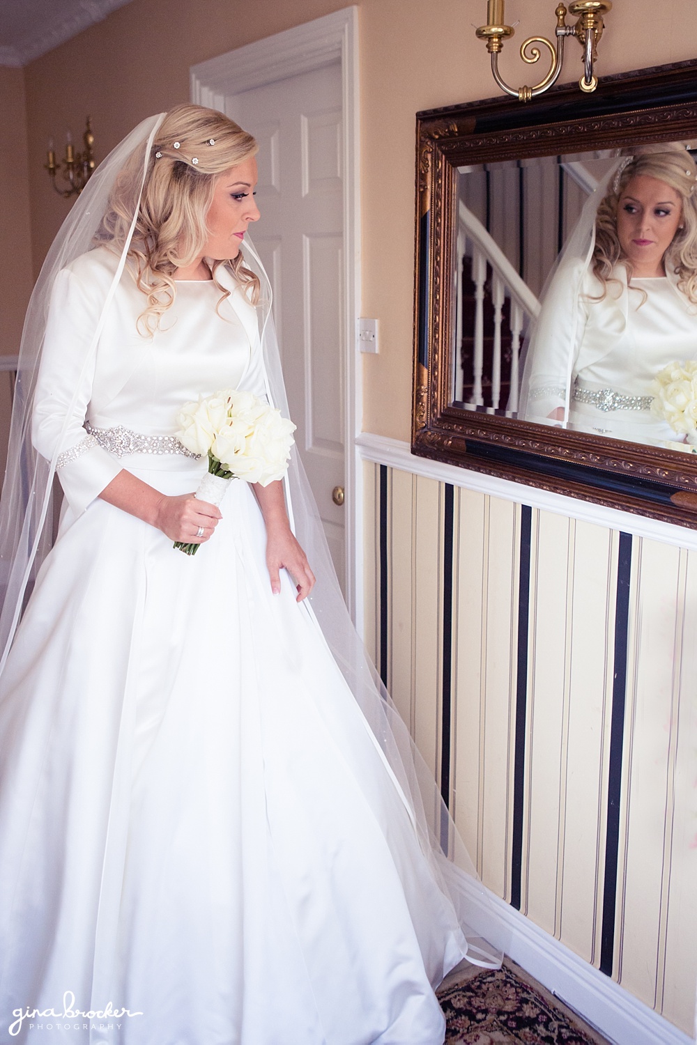 Classic Bride looks in the mirror before heading to the church for the ceremony