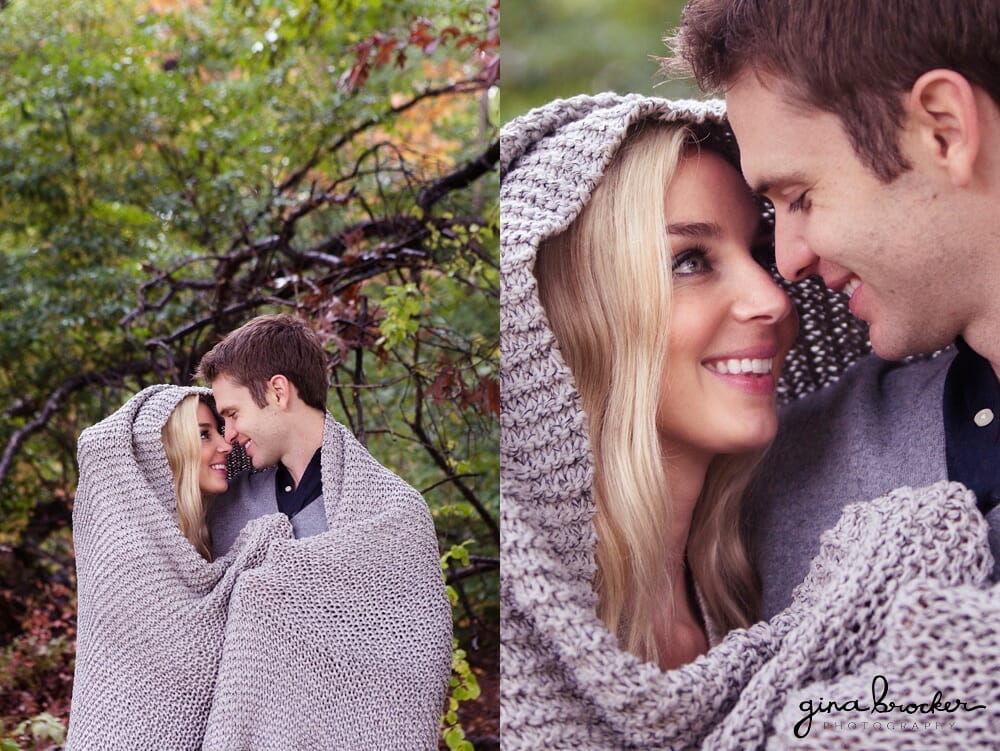 A couple share a sweet moment as they are wrapped in a blanket during their woodsy engagement session in massachusetts