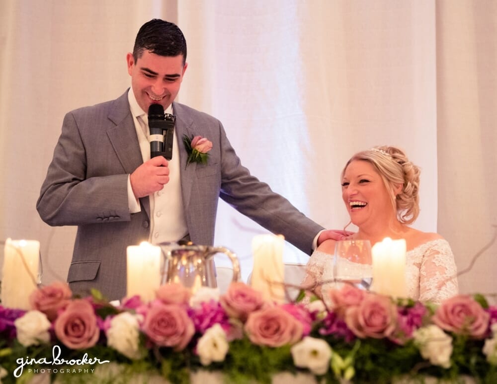 Bride smiles as groom gives wedding speech