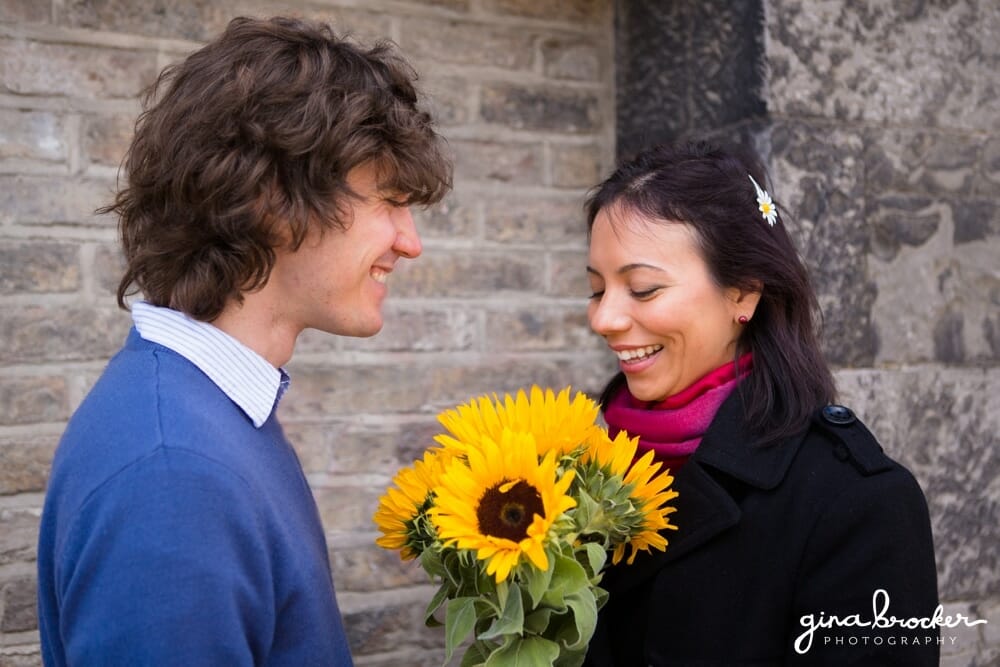 A husband gives his wife sunflowers when the meet for their love story session in Boston