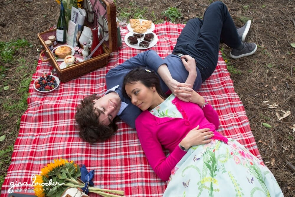 Couple laying on blanket during picnic love story session in Boston