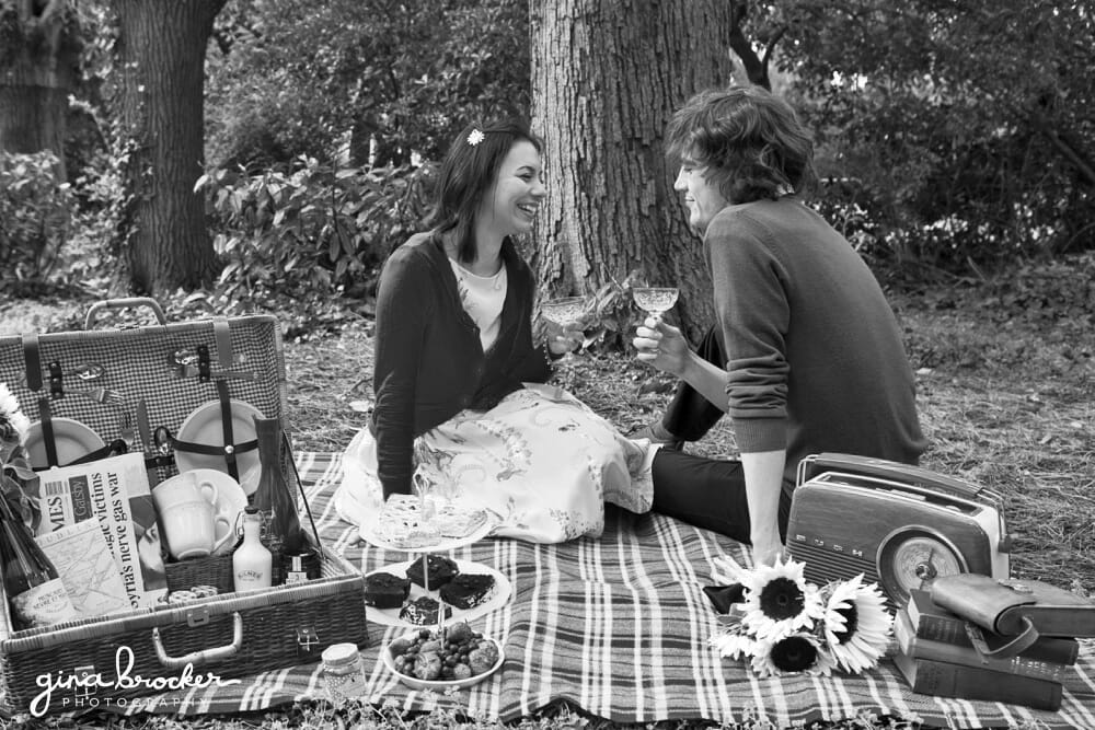 couple sit on picnic and drink champagne during their picnic love story shoot in Boston Common