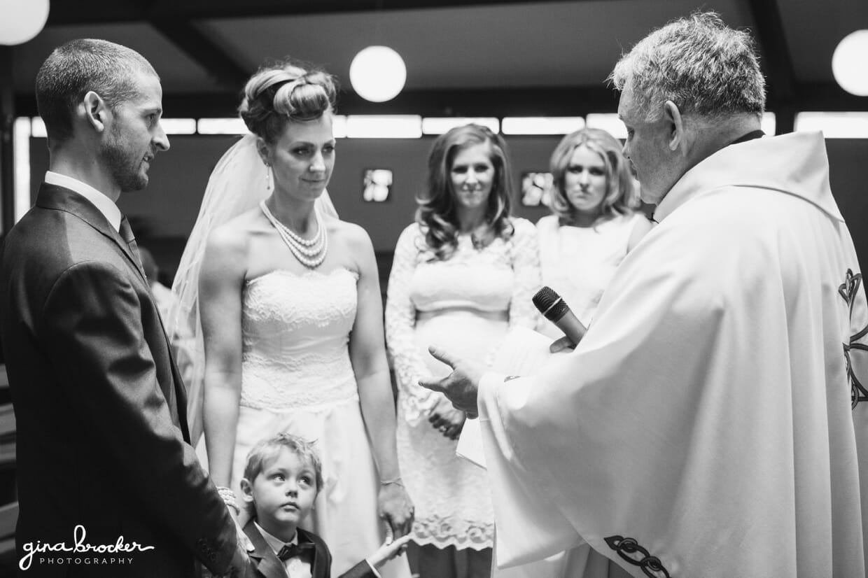 The bride and groom make their wedding vows with the son, bridesmaids and groomsmen standing beside them