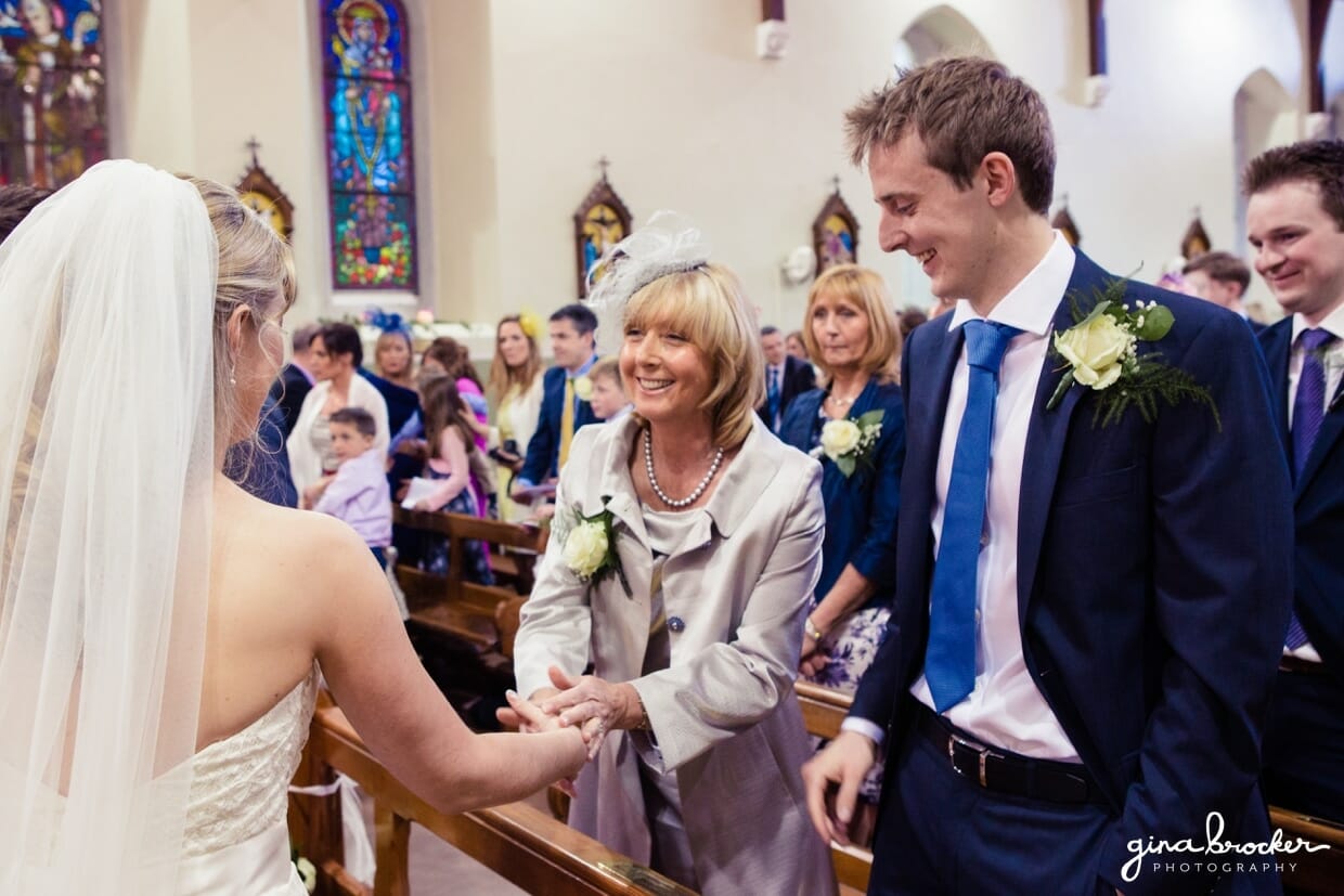The mother of the bride shakes her daughter's hand after she is pronounced husband and wife