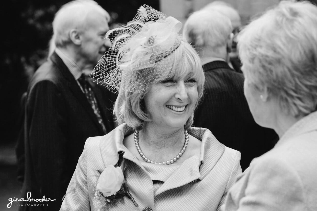 The mother of bride laughs while she talks to her friend at a classic vintage wedding