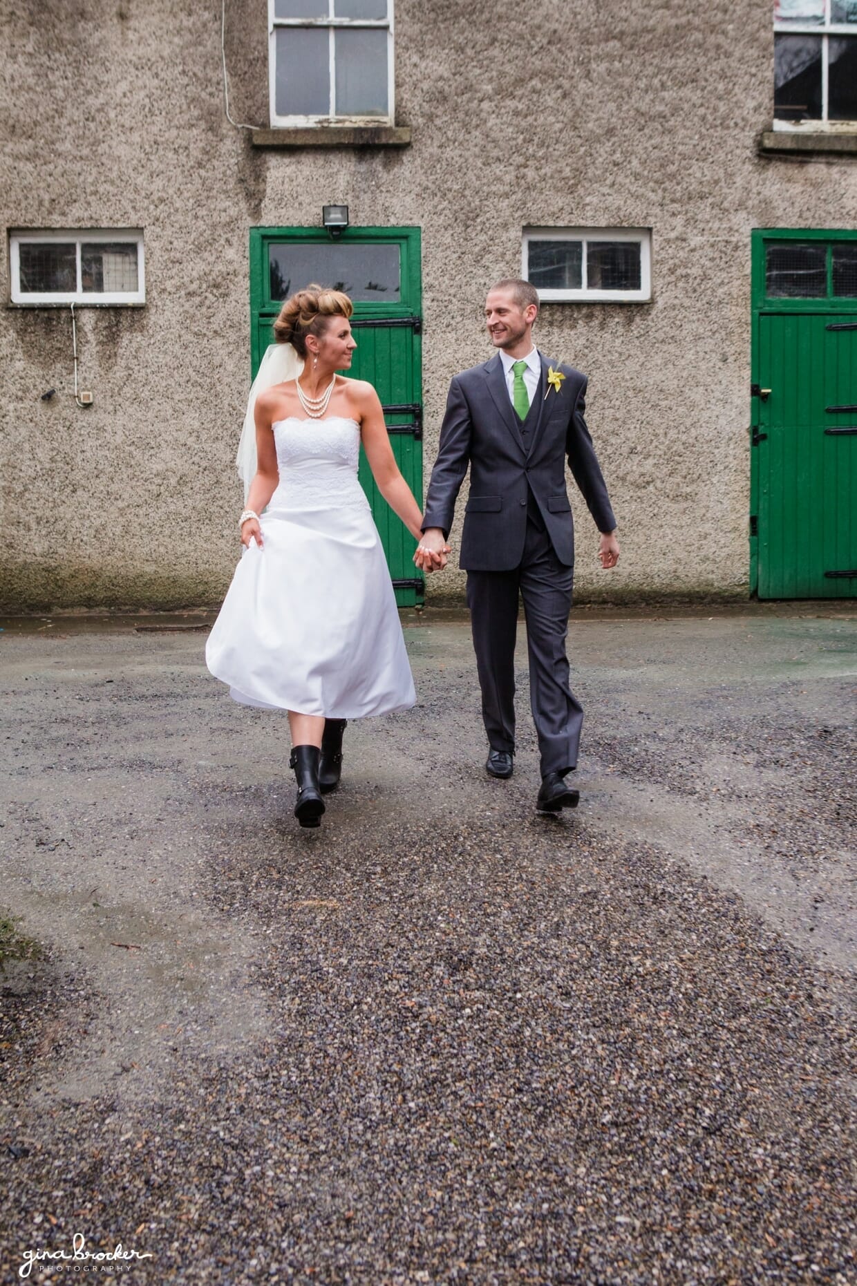 A natural wedding portrait of the retro bride wearing a tea length dress and her groom wearing a gray suit. 