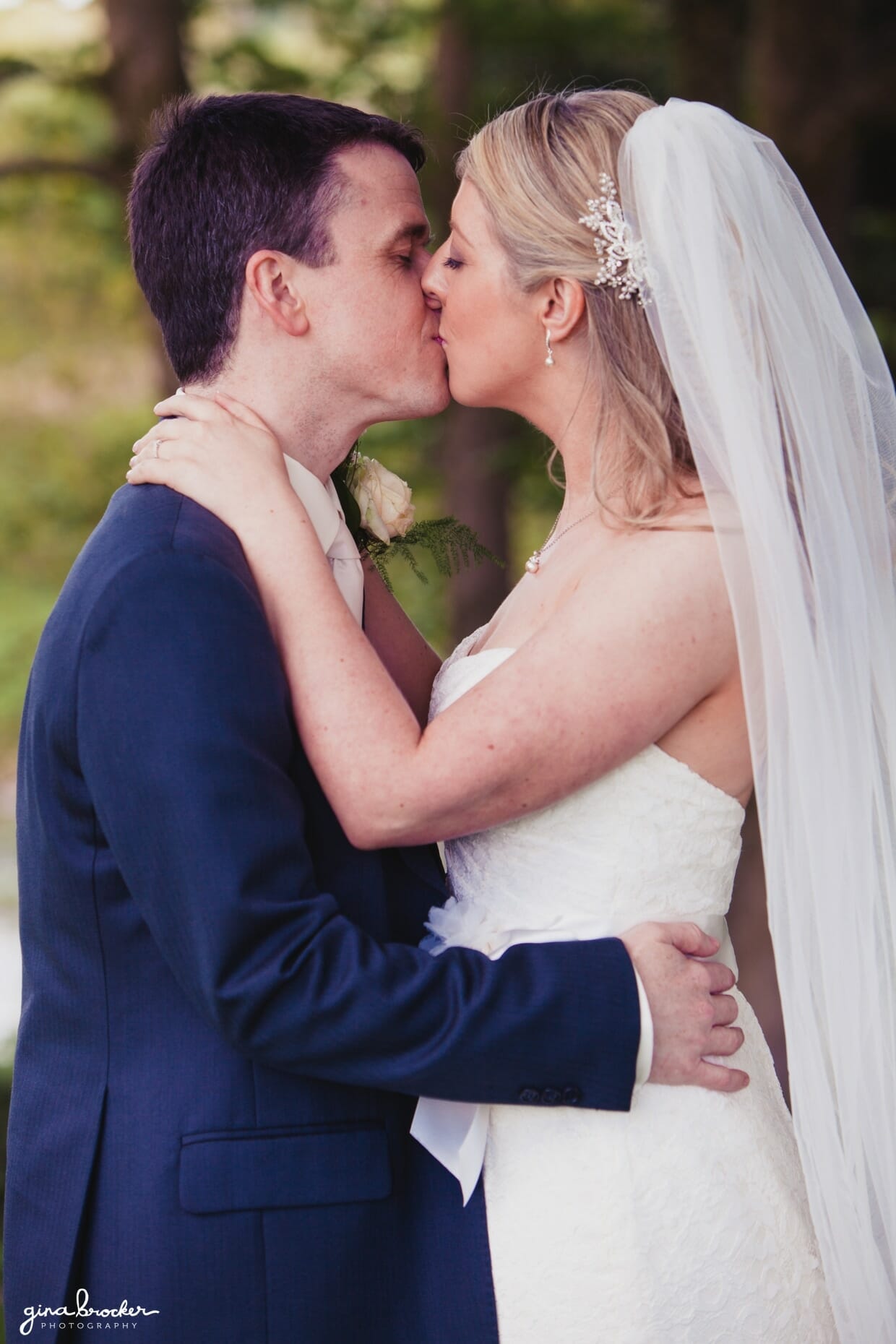 The bride and groom kiss in the woods after their beautiful wedding ceremony