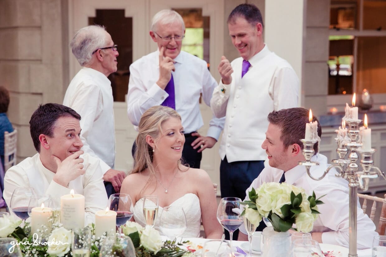 A candid photograph of the bride and groom talking with their guests during their intimate wedding reception