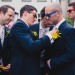 A groom helps his groomsmen get ready on the morning of his colorful and fun wedding in Boston, Massachusetts