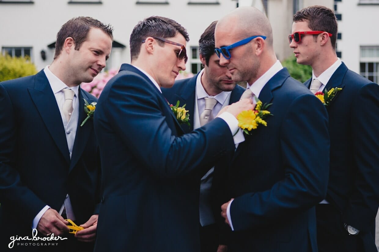 The groomsmen put on each others boutonnieres before leaving for the wedding ceremony
