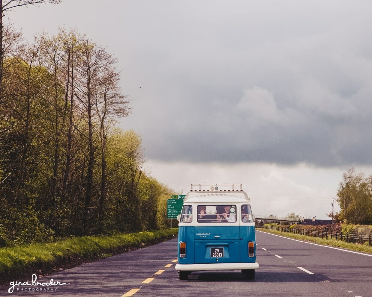 A blue retro volkswagen bus drives the wedding party to the church