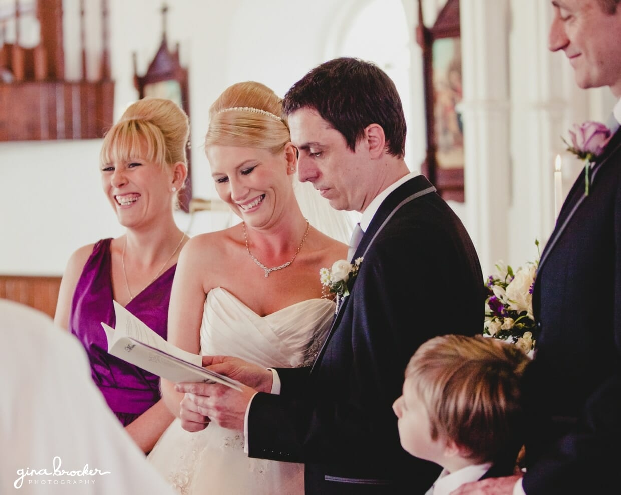 The bride and her bridesmaid smile while groom says his vows during their wedding ceremony is a small church