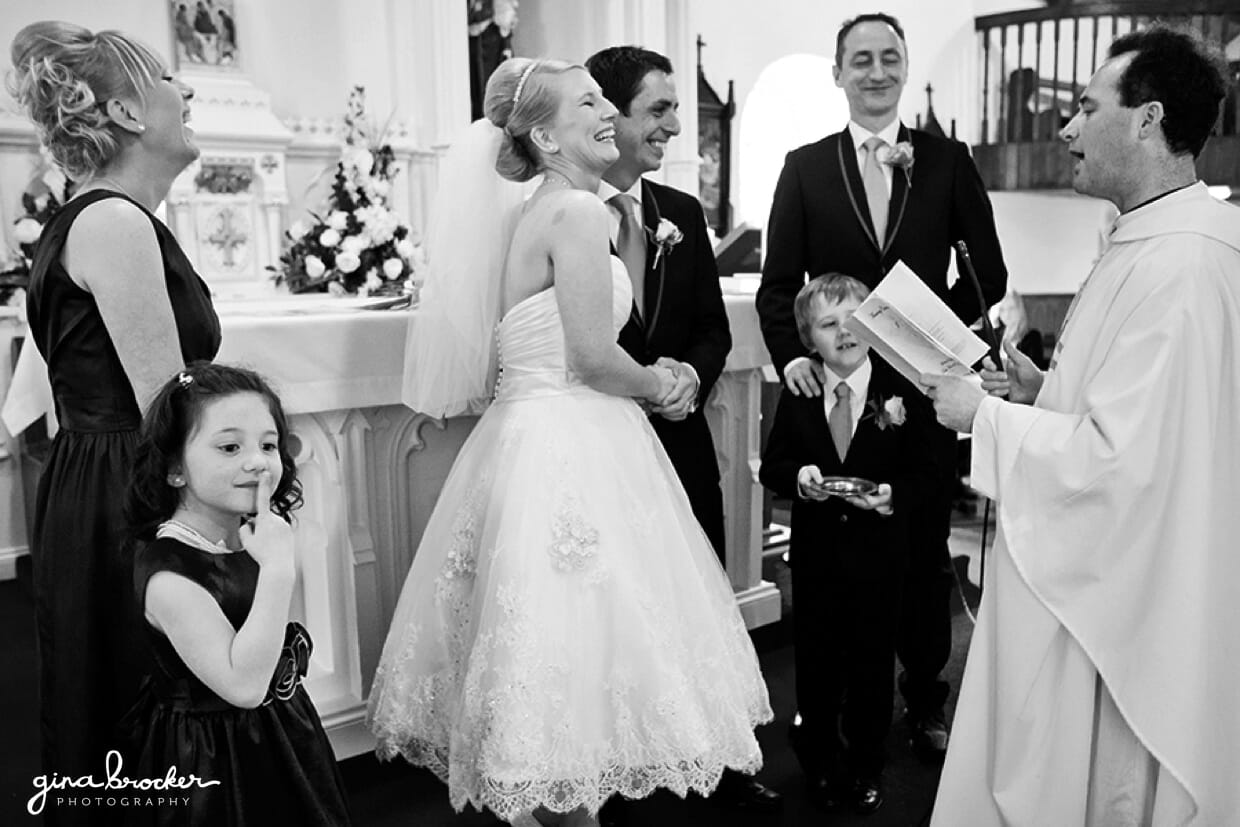 The wedding party laugh during an intimate wedding ceremony in a small church