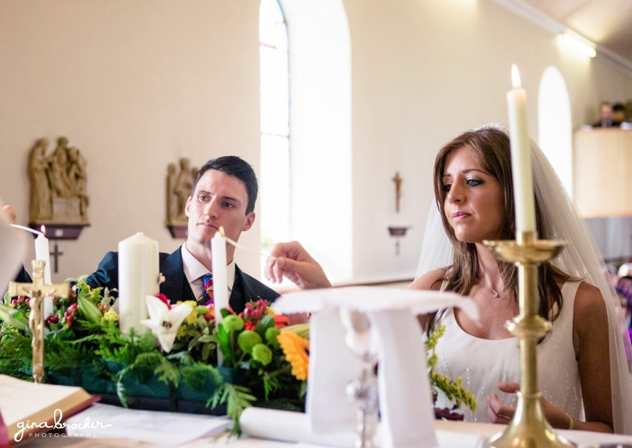 The bride and groom light a candle during their personal religious wedding ceremony in a small church