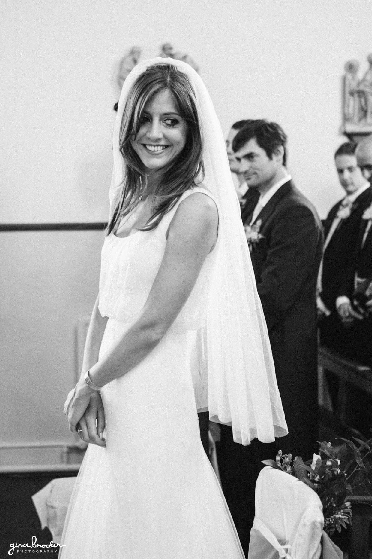 A bride smiles at her bridesmaids during her wedding ceremony in Boston, Massachusetts