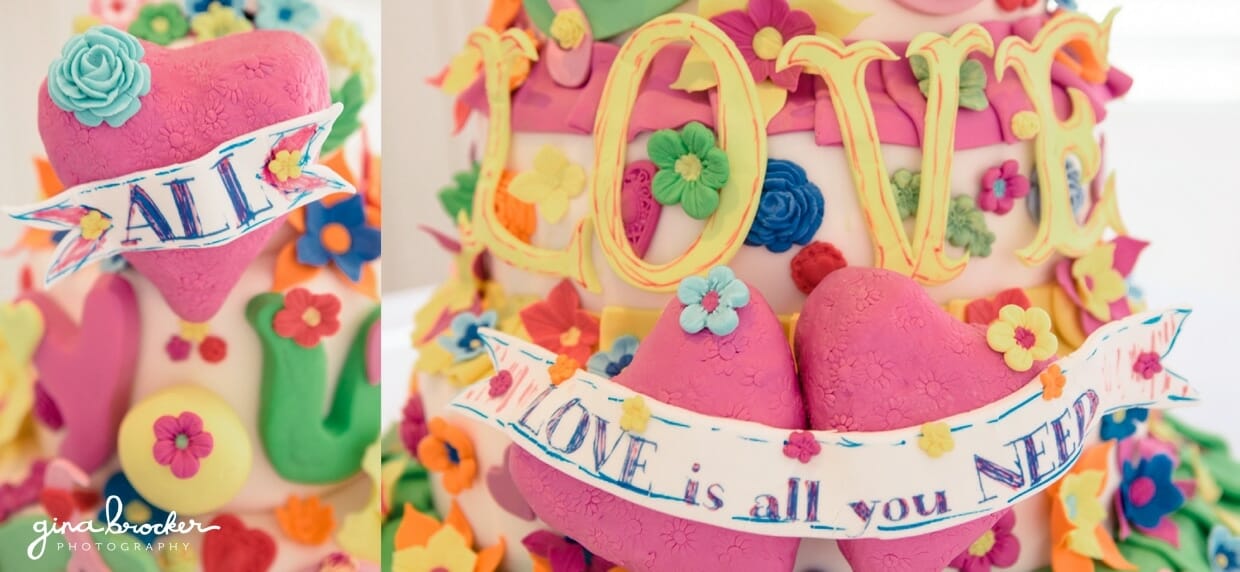 A colorful wedding cake with the phrase, all you need is love, love is all you need