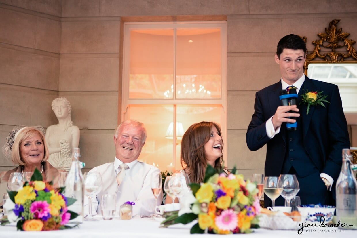 The bride and her parents laugh while the groom gives a funny wedding toast