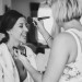 A bride laughs as she gets her makeup done on the morning of her Boston wedding