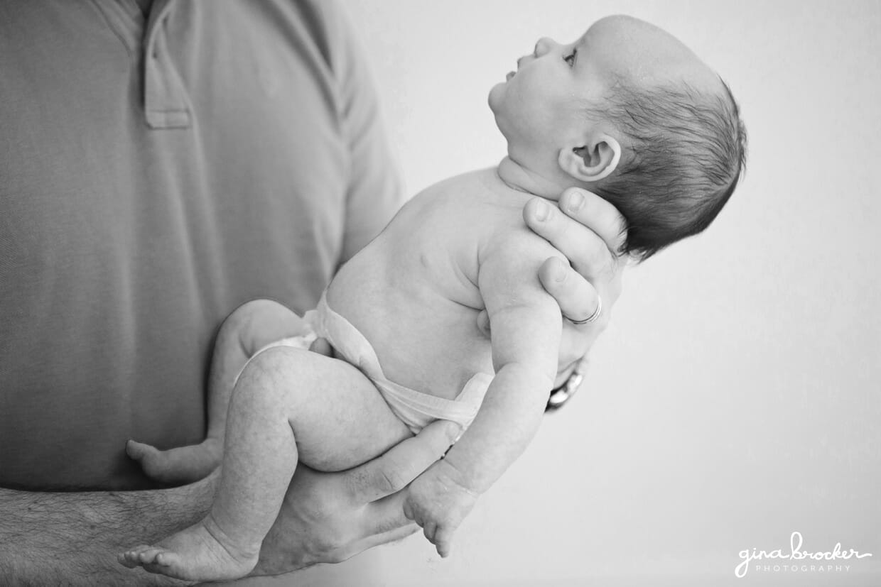 Photograph of a baby being held by her father during a family photo session at home in New England