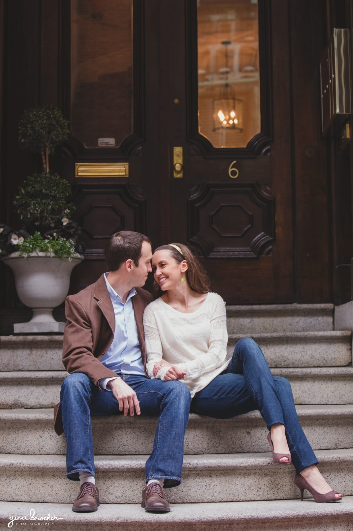 A couple sit on the steps of their Beacon Hill home during their relaxed and sweet Boston engagement session