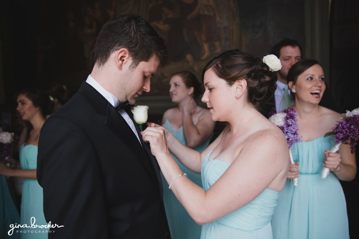A bridesmaids adjust the grooms boutonniere before his wedding ceremony at the Sacred Heart of Jesus Church in Cambridge, Massachusetts