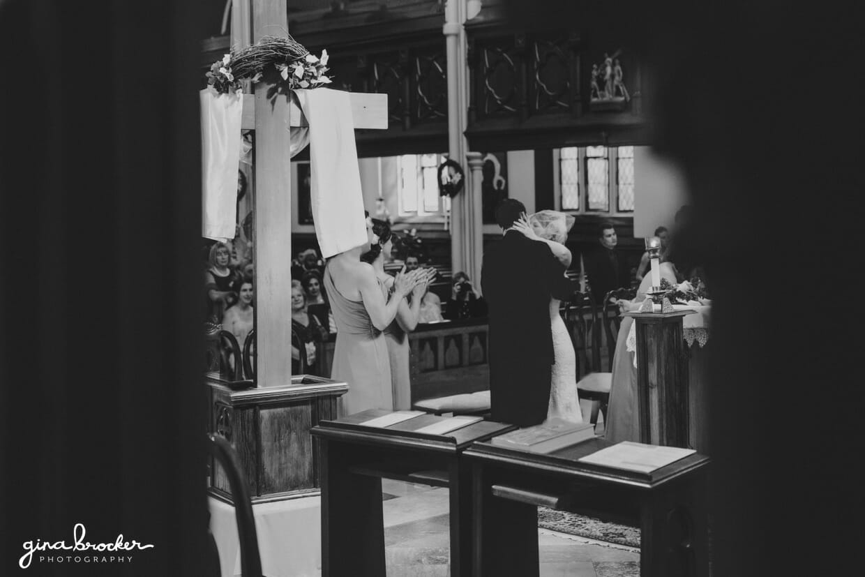 A bride and groom share their first kiss as husband and wife during their wedding ceremony at the Sacred Heart of Jesus Church in Cambridge, Massachusetts