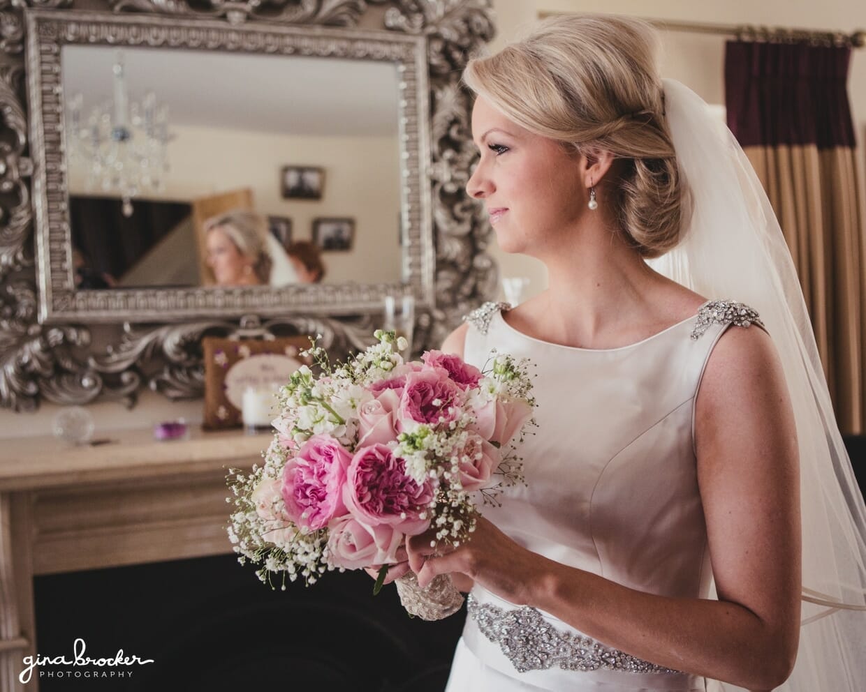 A natural and candid portrait of a bride holding a rose bouquet on the morning of her classic wedding