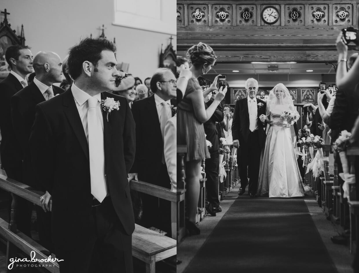 The groom watches his bride walk up the aisle with her father during their wedding ceremony in a church