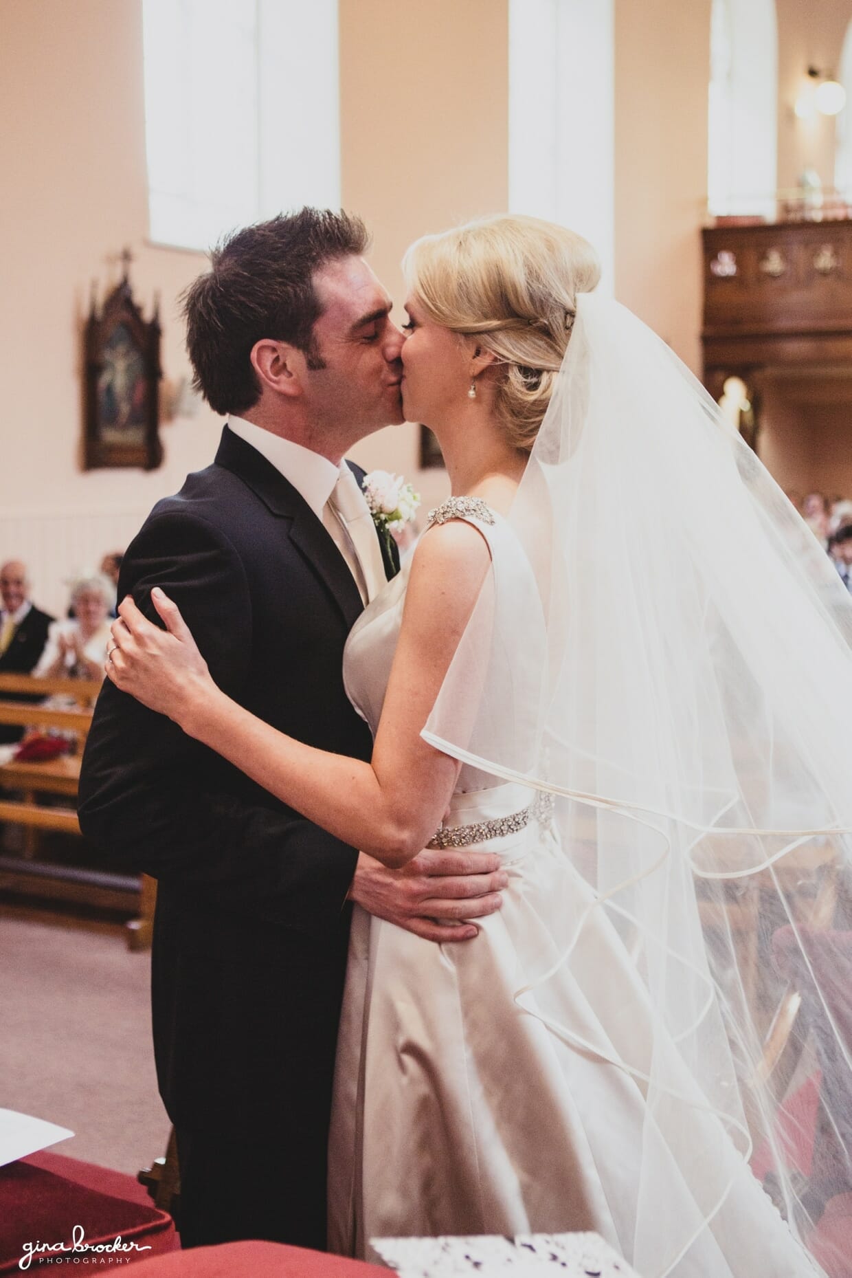 The bride and groom share their first kiss as husband and wife after saying i do at their religious wedding ceremony