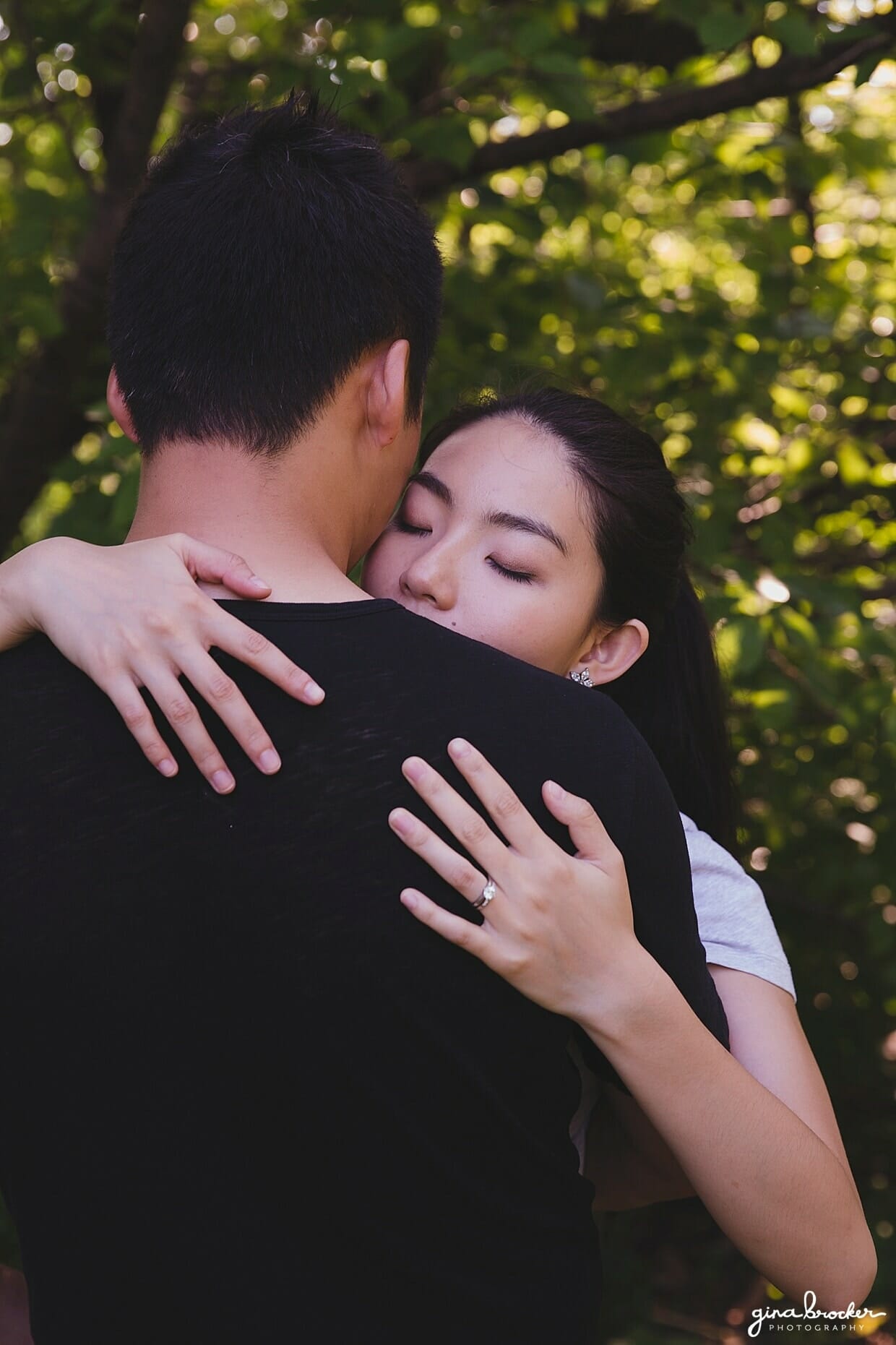A couple hug during their park engagement session in Boston's Back Bay Fens