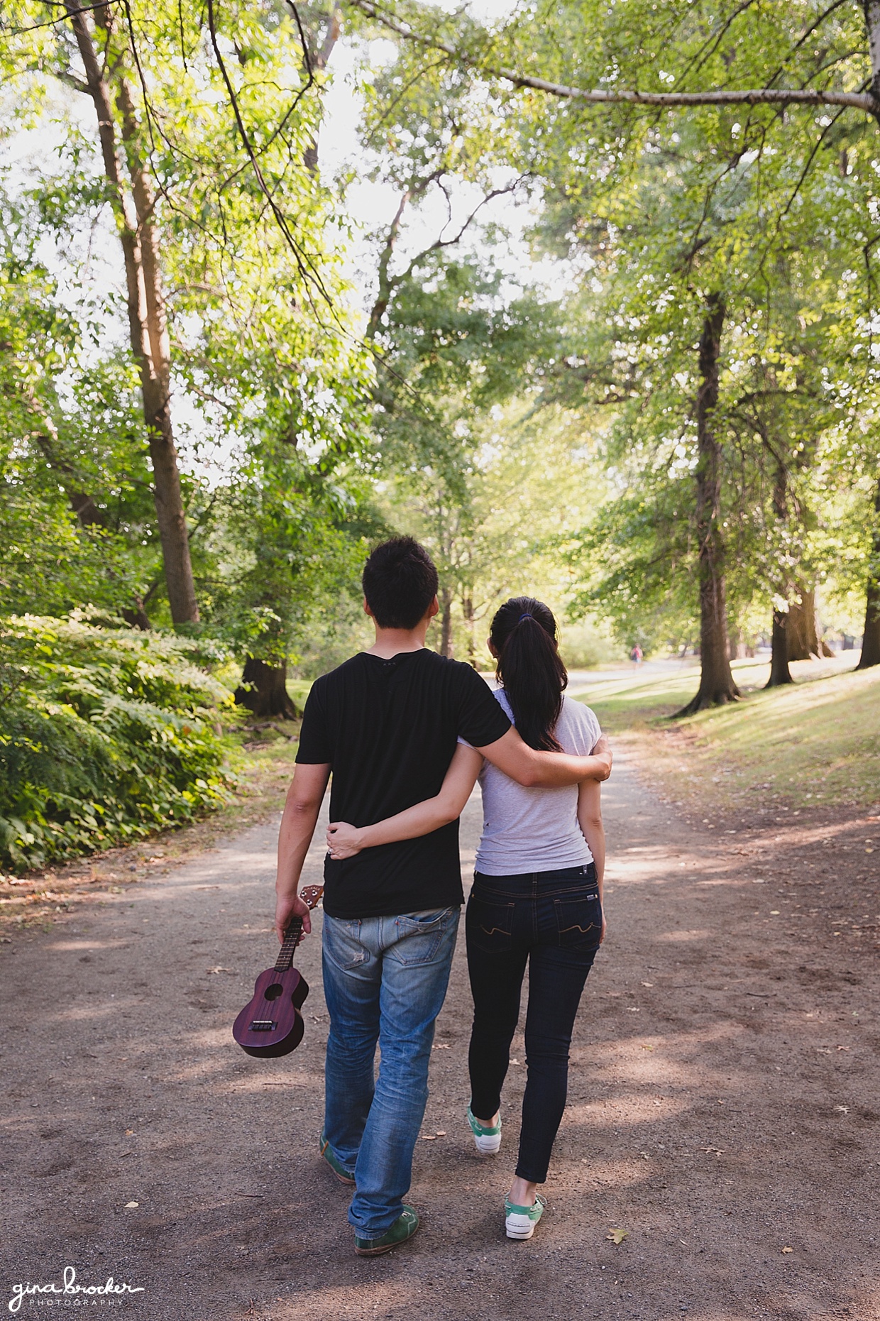 A couple walk together during their park engagement session in Boston's Back Bay Fens