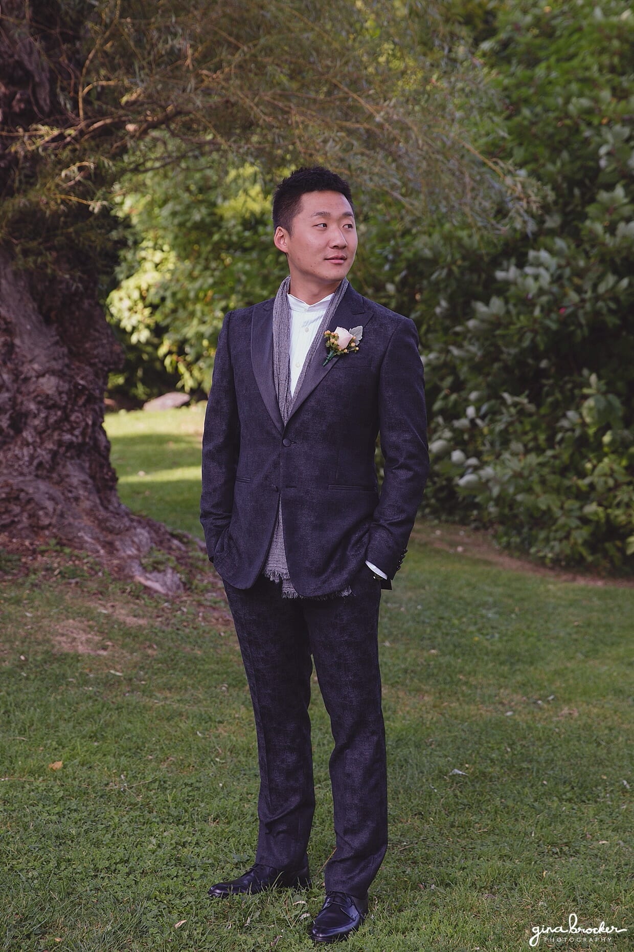 A portrait of a groom wearing a charcoal gray John Varvatos suit at Mill Pond Park in Rockport, Massachusetts 