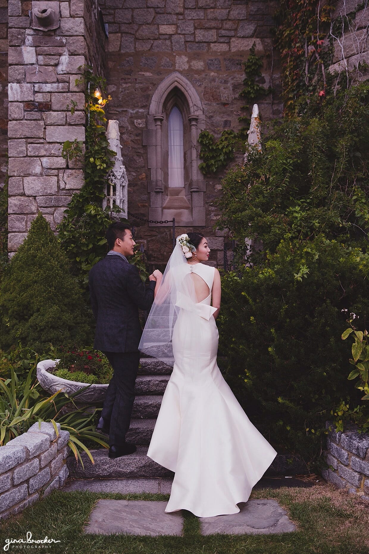 The bride and groom walk into Hammond Castle after their beautiful outdoor wedding ceremony