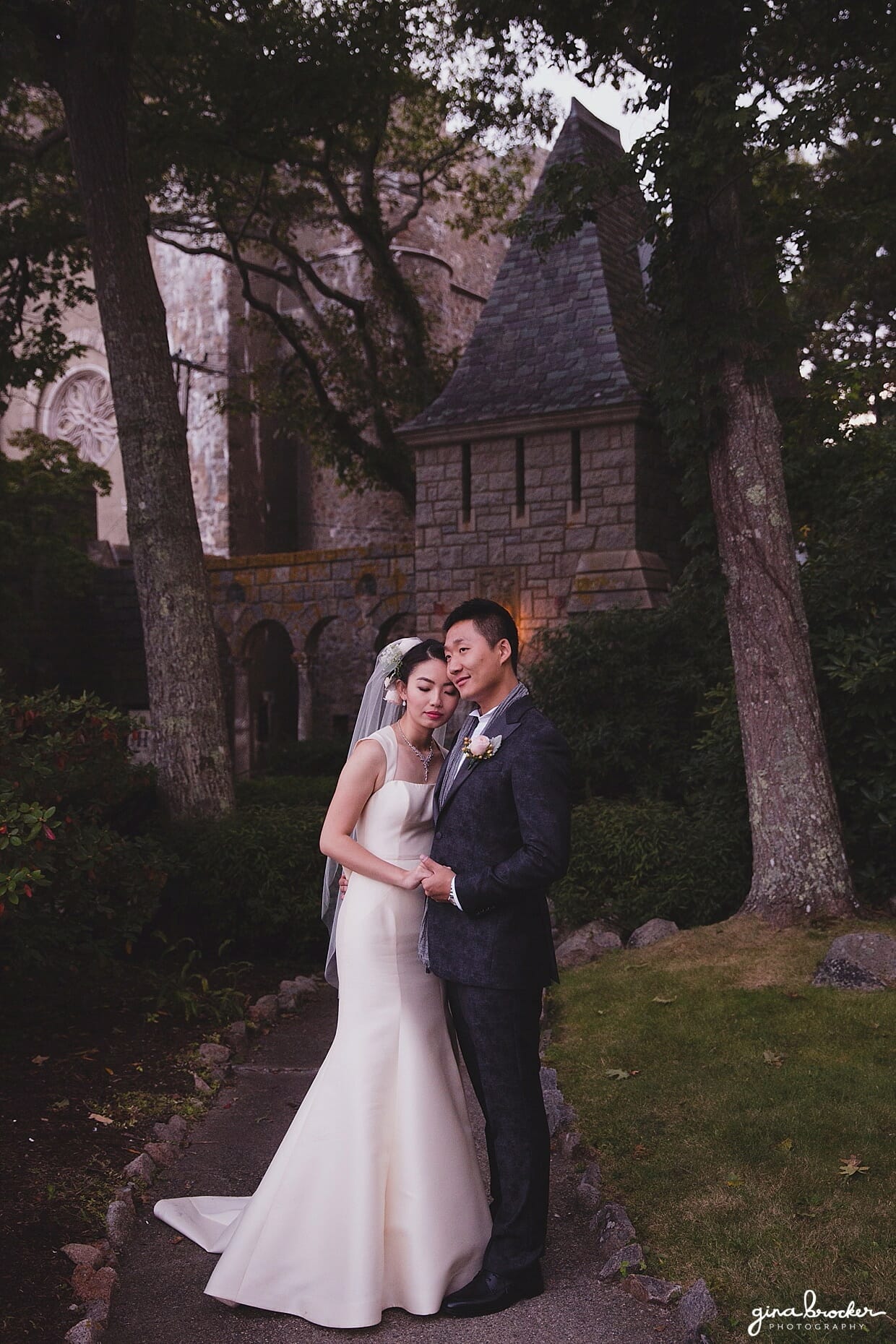 A sunset portrait of a bride and groom wearing an Amsale wedding dress and John Varvatos suit during their Hammond Castle wedding in Gloucester, Massachusetts
