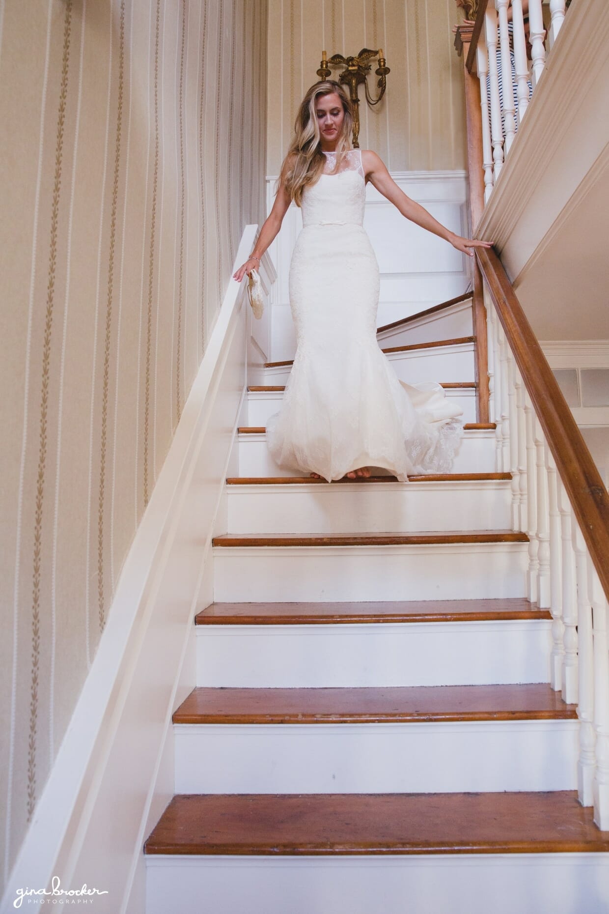 The bride walks down the stairs in her wedding dress on the morning of her Nantucket Wedding at the Westmoor Club