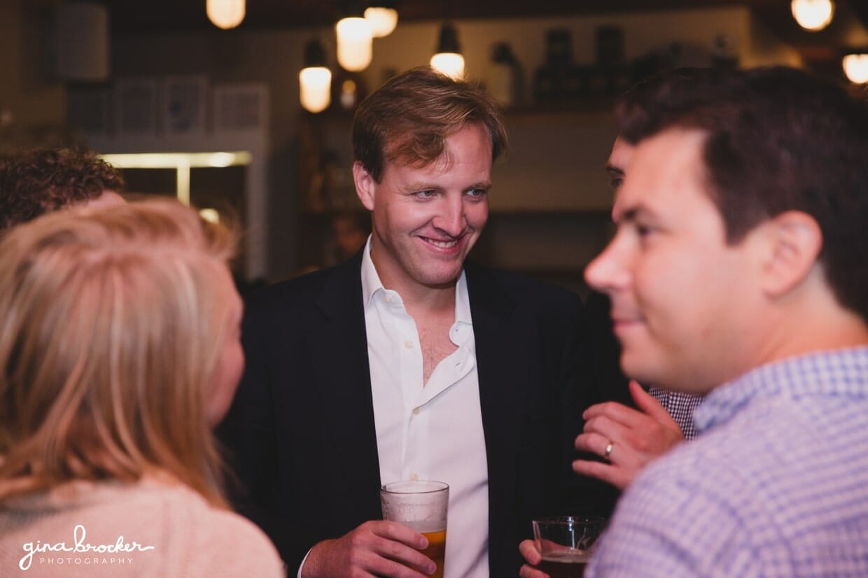 A candid photograph of guests talking during a wedding rehearsal dinner at Backyard BBQ restaurant in nantucket, Massachusetts