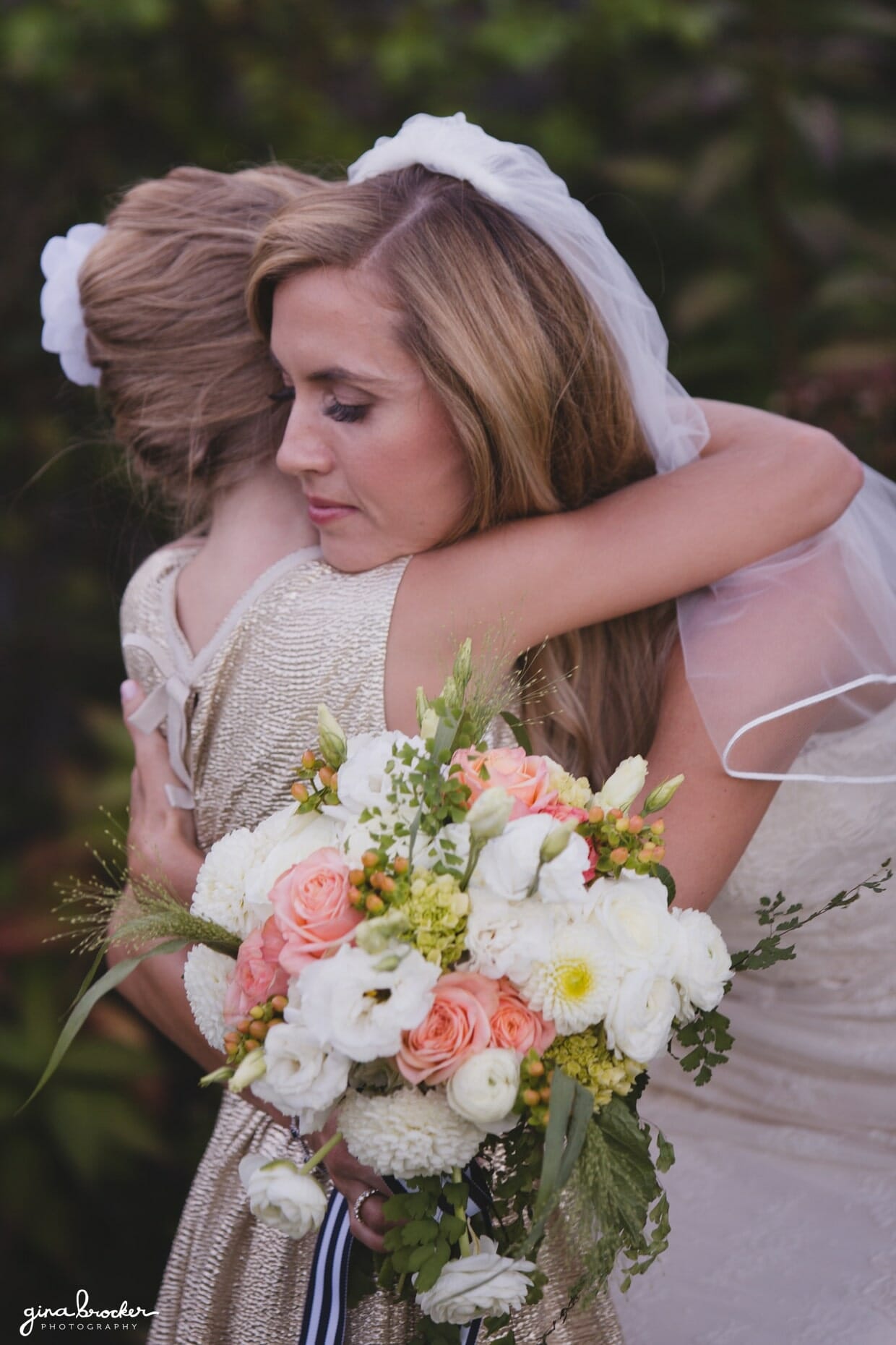 A bride hugs her flower girl moments after her wedding ceremony at the Westmoor Club in Nantucket, Massachusetts