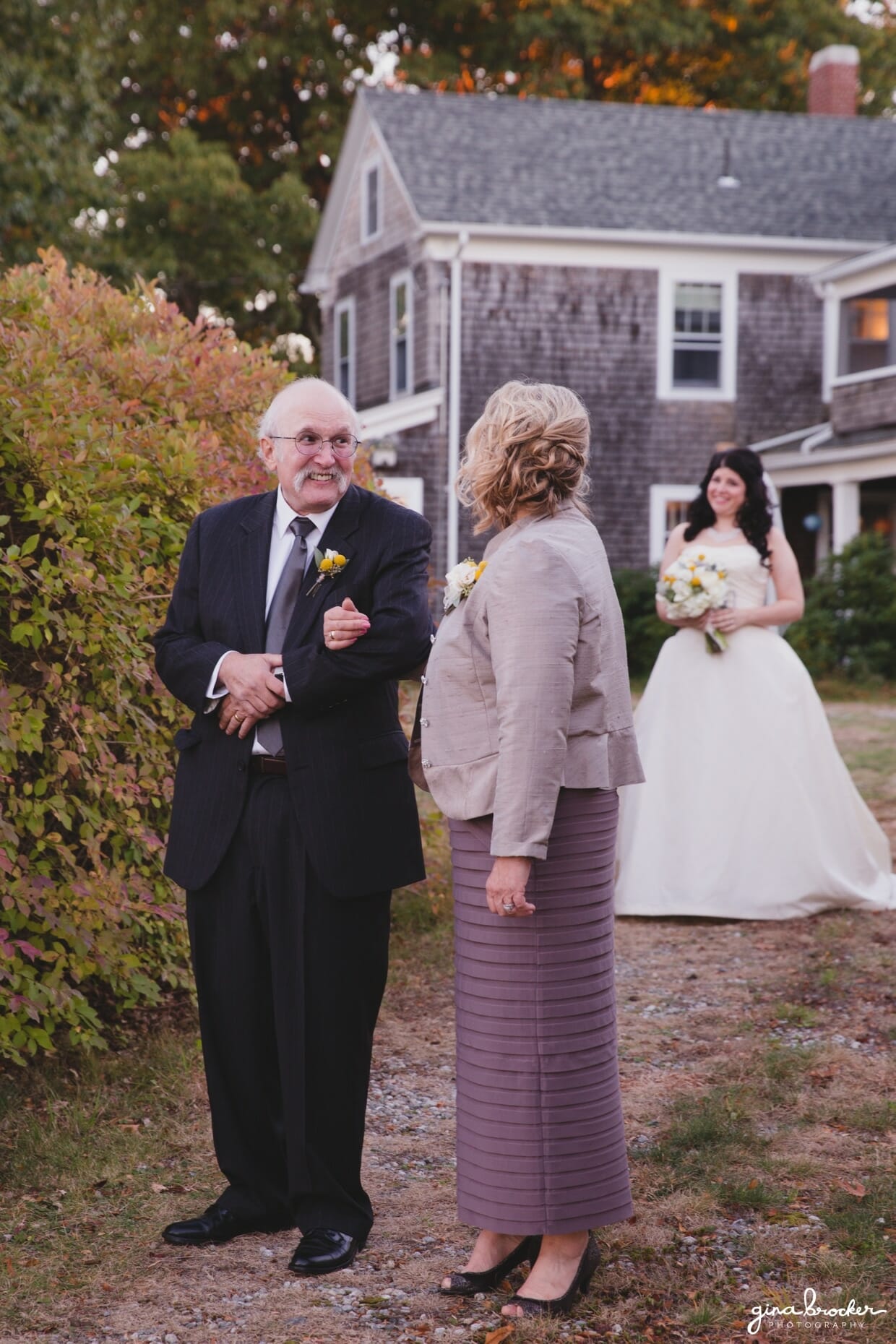 A cute and candid photograph of a bride waiting to walk up the aisle with her parents during her farm wedding in Oxford, Massachusetts