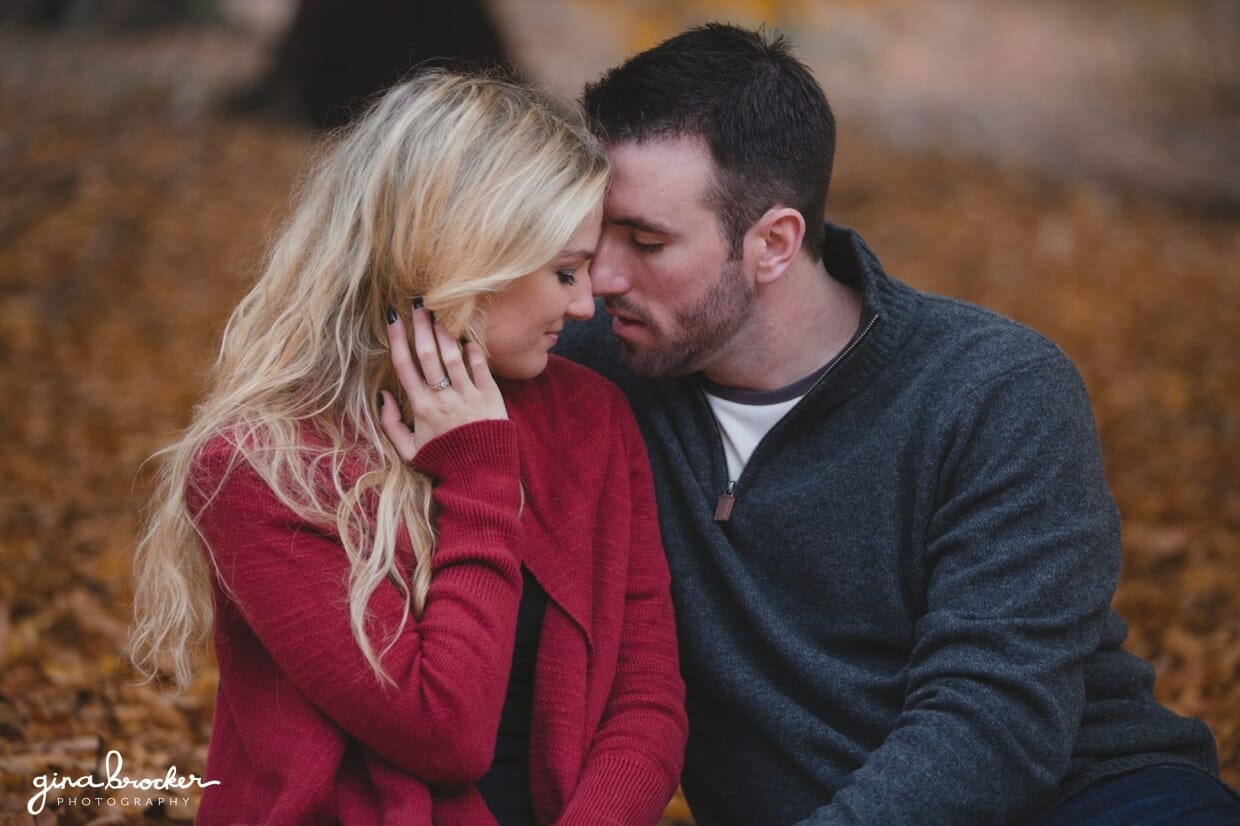 A sweet photograph of couple snuggling on a blanket during a fall photo session in Boston's Arnold Arboretum