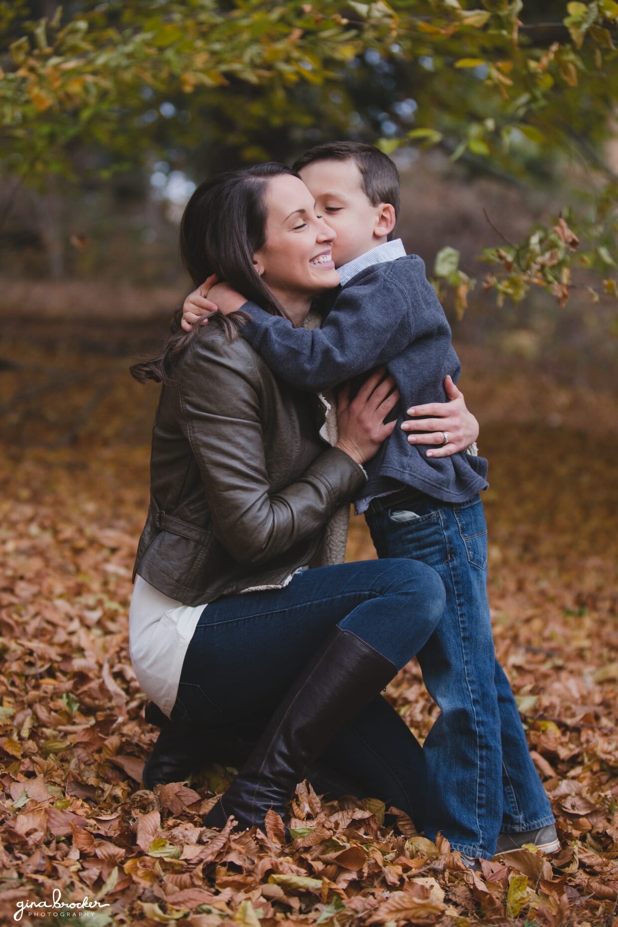 A sweet photograph of a son hugging his mom during a fall family photo session at the Arnold Arboretum in Boston, Massachusetts