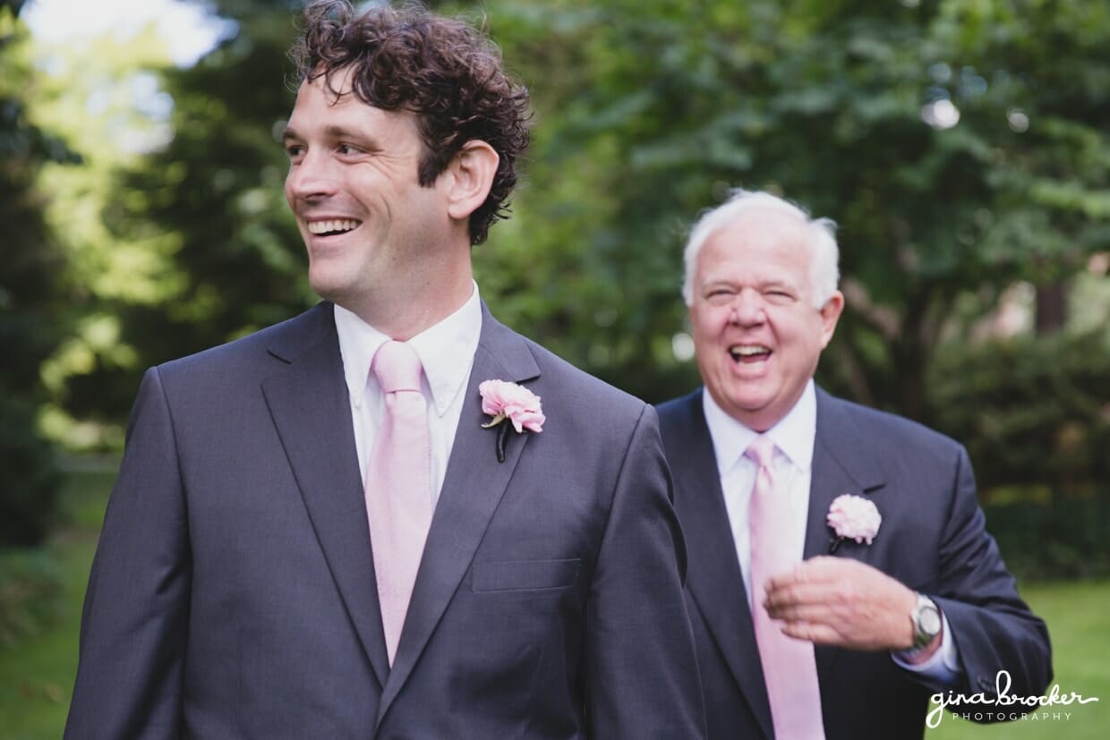 A candid photograph of a groomsmen and the father of groom laughing during a classic and elegant wedding