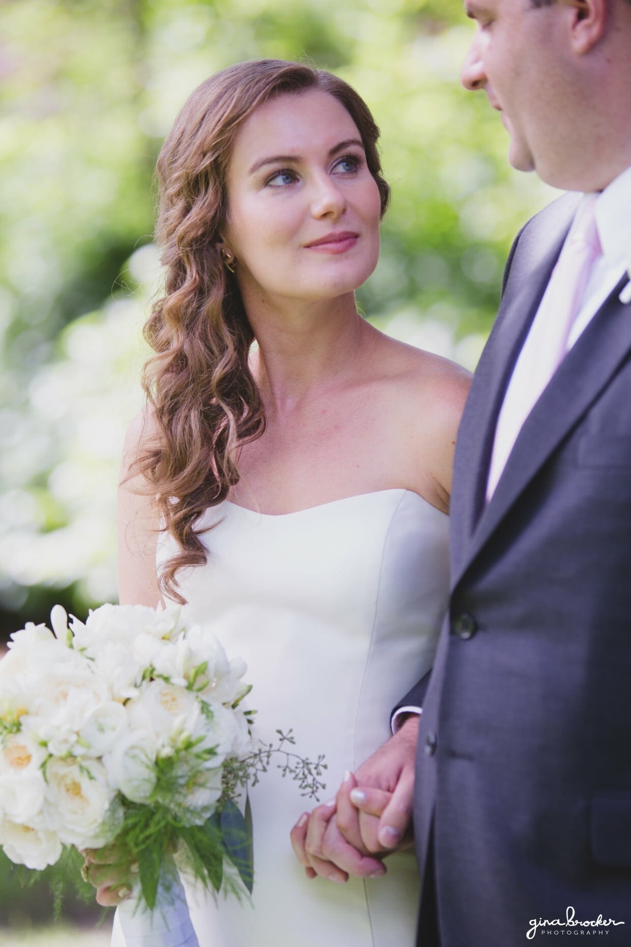 A sweet portrait of a bride looking up at her groom while holding a classic and elegant white bouquet