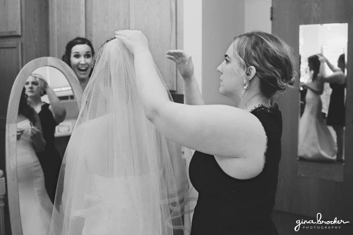 Bridesmaids put a veil on the bride before she walks down the aisle at her classic and elegant Boston Wedding