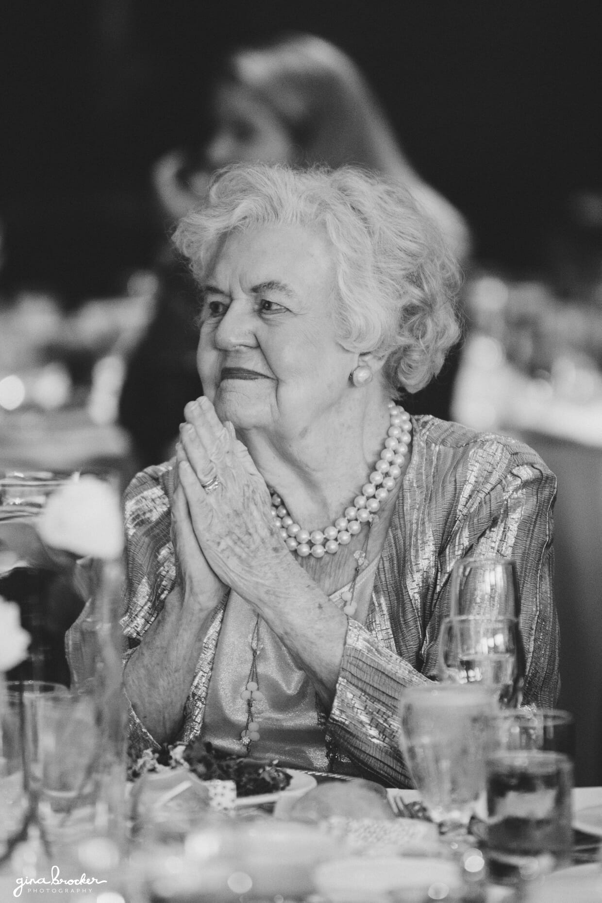 A candid and emotional portrait of a grandmother during the speeches of a classic and elegant Boston wedding in Massachusetts