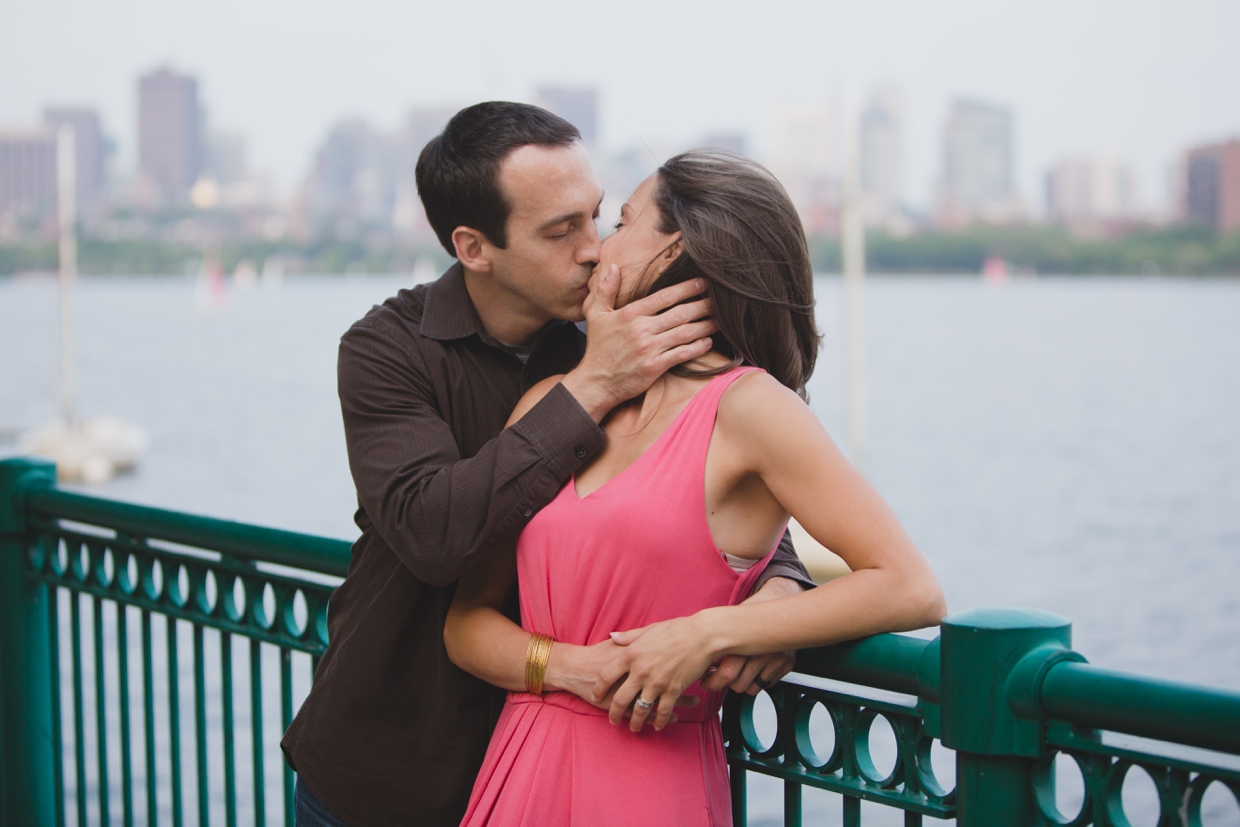 A romantic photograph of a couple kissing on the Charles River during their couple session in Boston, Massachusetts.
