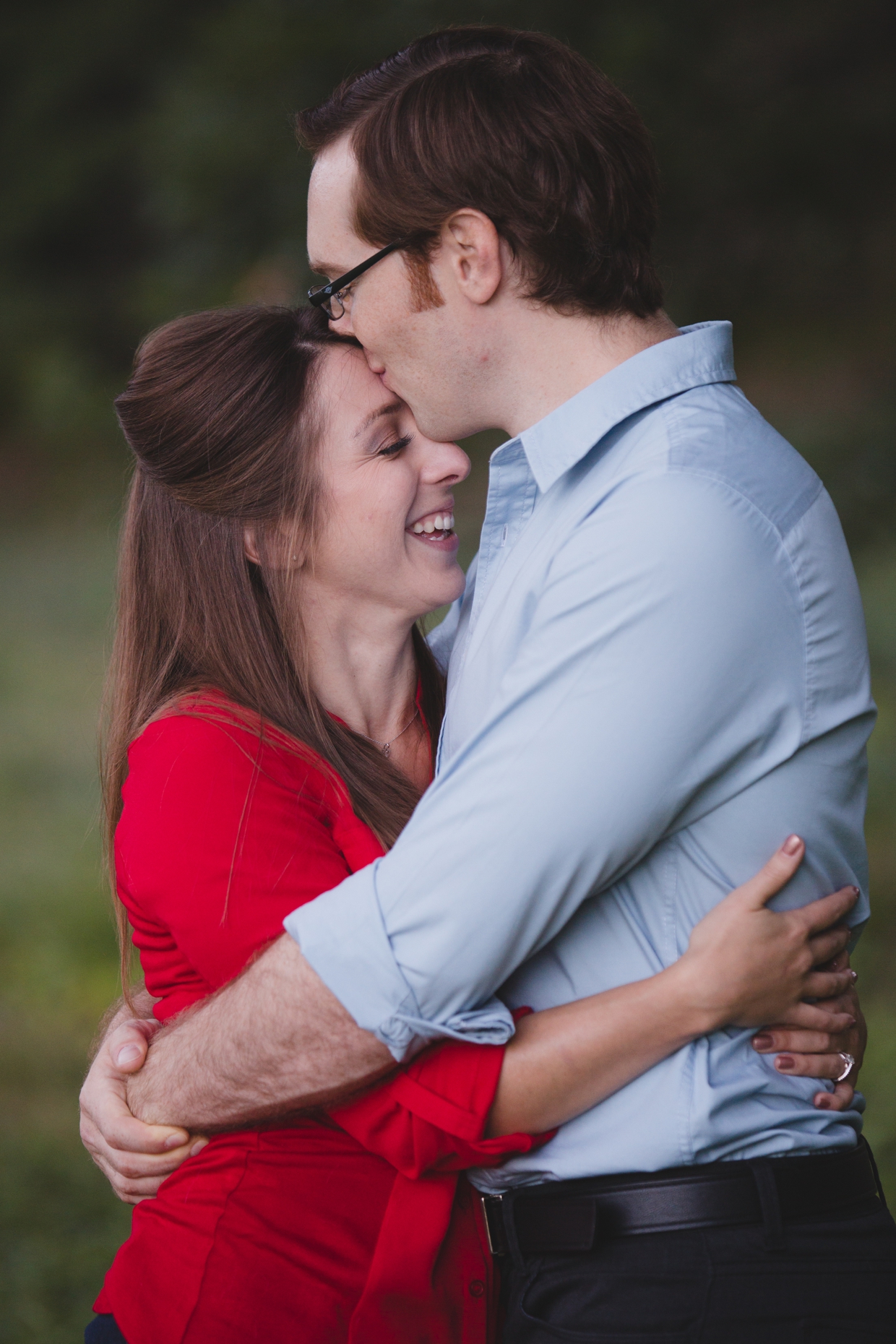 A couple hug and laugh during their engagement session at the Arnold Arboretum in Boston, Massachusetts