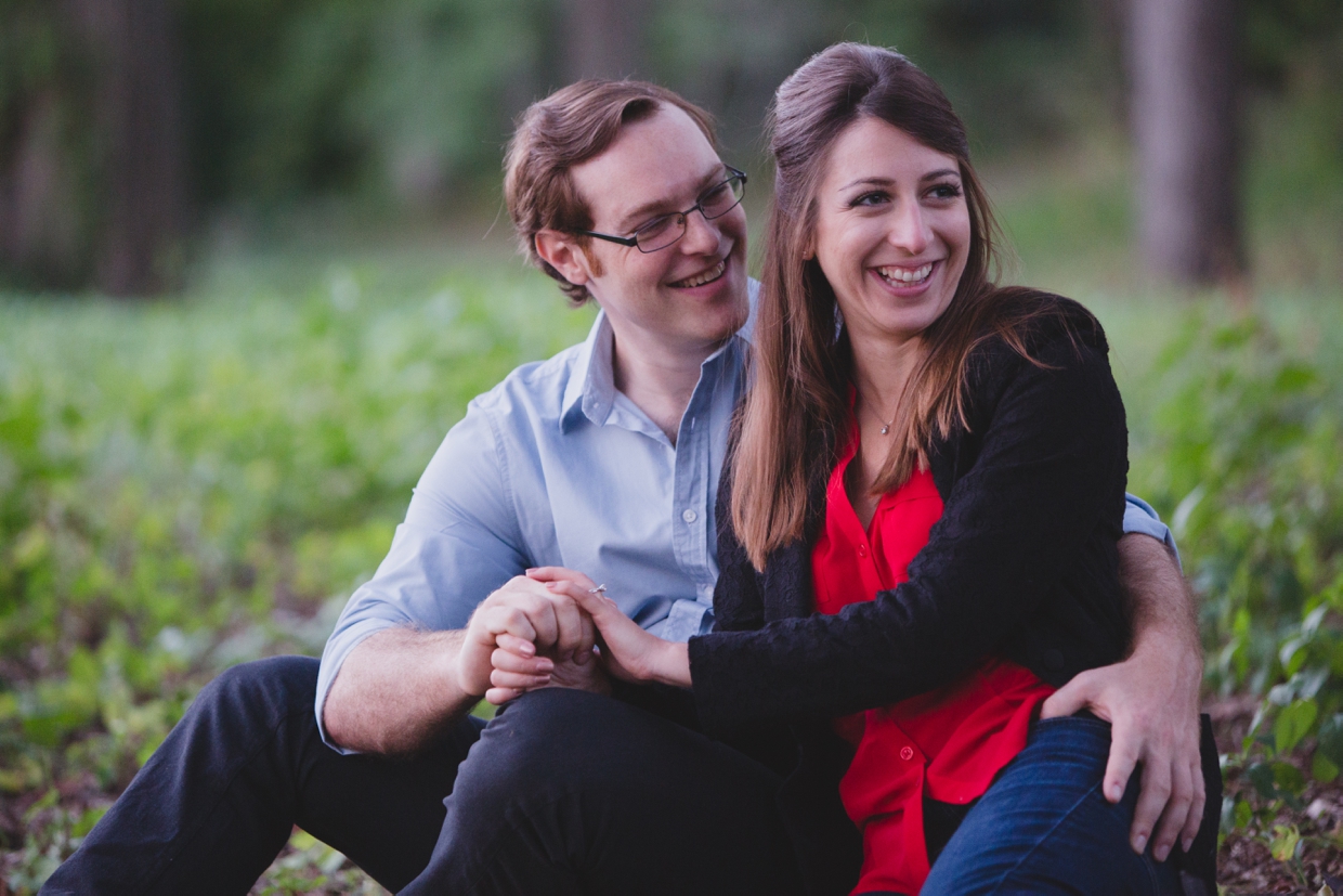 A cute and natural photograph of a couple laughing during their engagement session at the Arnold Arboretum